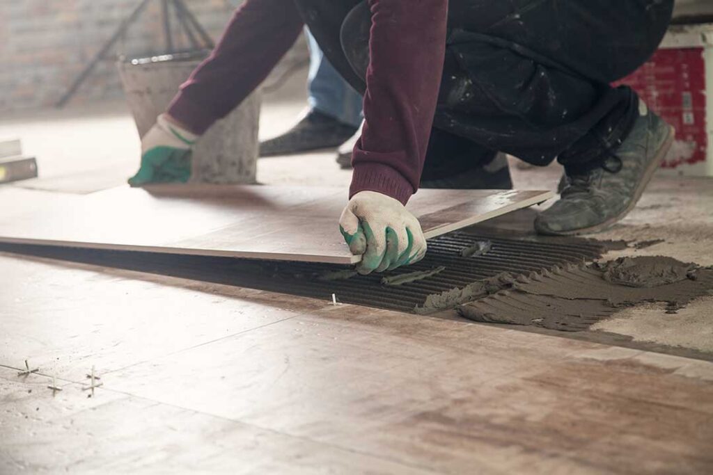 Warm wood flooring, patterned tile, and textured samples arranged in a bright home interior.