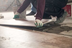 Warm wood flooring, patterned tile, and textured samples arranged in a bright home interior.
