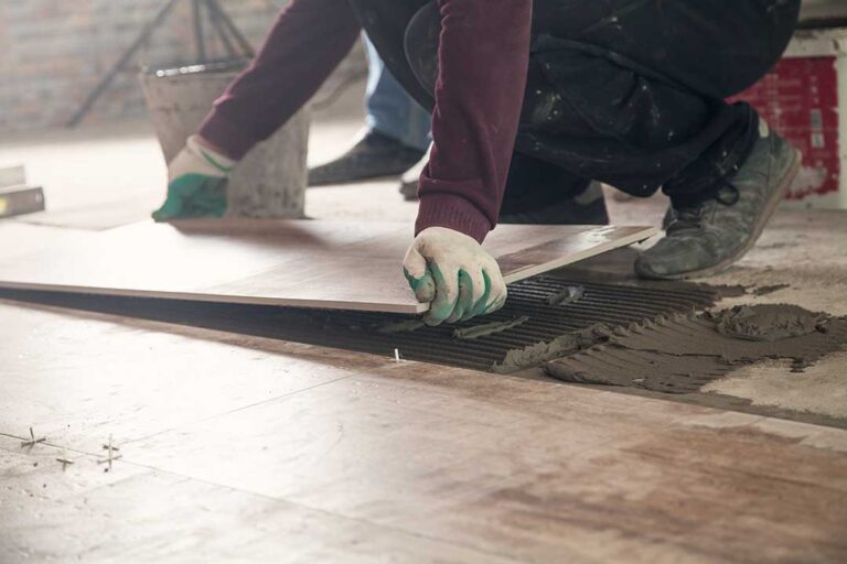 Warm wood flooring, patterned tile, and textured samples arranged in a bright home interior.